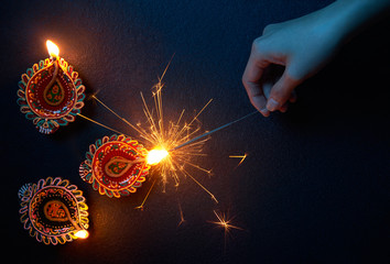 Lighting a sparkler with diya lamp