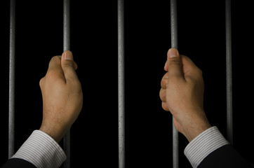 Business executives to prison with a dark background.Looking at the freedom within the prison