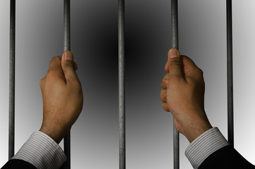 Business executives to prison with a dark background.Looking at the freedom within the prison