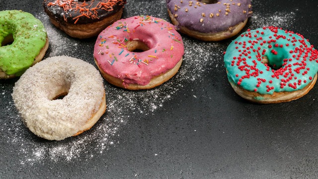 Donuts with a colorful icing on a dark background