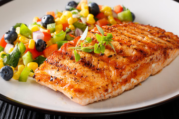 Grilled salmon with Mexican salsa of vegetables and berries close-up. horizontal