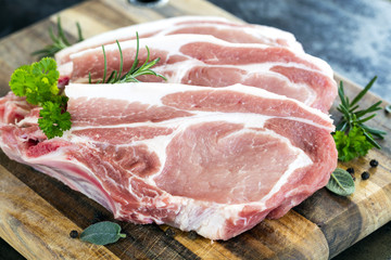 Raw Pork Chops on board with Herbs and Spices