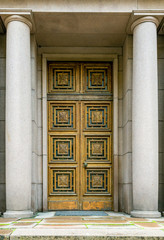 Old decorative wooden door with  stony columns ornamentation