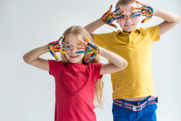 Two boys with painted colored rainbow hands
