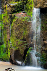close up of waterfall cascade over the mossy rock. beautiful calm nature background. freshness and...