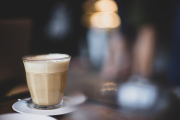 glass of latte coffee with blurred bokeh background at cafe