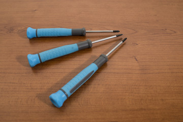 Tools, blue screwdriver on a walnut table