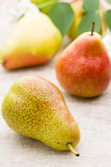 Fresh pears with leaves in a on wooden background.