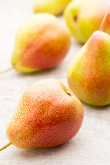 Fresh pears with leaves in a on wooden background.
