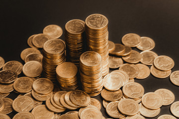 Savings, increasing columns of coins, piles of coins arranged as a graph in dark room, business banking concept.