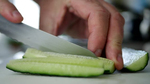 Close Image With Man Hands In Kitchen Cutting Flavored Cucumber in Fresh Slices