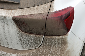 Dried mud on the rear light on a white car