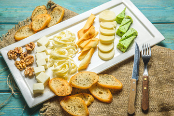 Fototapeta na wymiar cheese set on a plate on blue wooden background