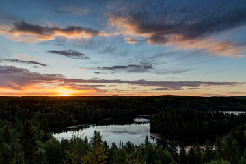 Naklejka na ściany i meble Scenic and beautiful view of a lake, forest and sky from the Aulanko lookout tower in Hämeenlinna, Finland, in the summer at sunrise. Copy space.