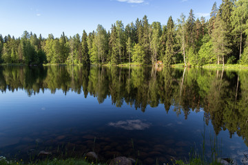 Fototapeta na wymiar Beautiful view of a small lake Metsälampi and forest at the Aulanko nature reserve in Hämeenlinna, Finland, on a sunny day in the summer.