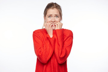 Worried female looks nervously, bites finger nails, watches  thriller movie, anticipates what end...