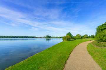 Fototapeta na wymiar Willen Lake with pedestrian path at sunny summer day 