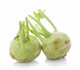 Fresh kohlrabi with green leaves on isolated white backround