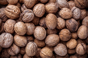 Walnuts close up large rustic arrangement in shell overhead on dark background in studio