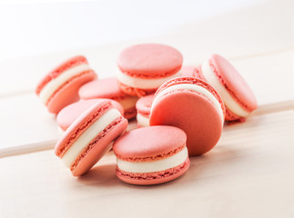 Pink macaroons fresh close up arrangement on white wooden table