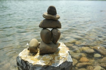 Rock balancing against the background of the river and sky