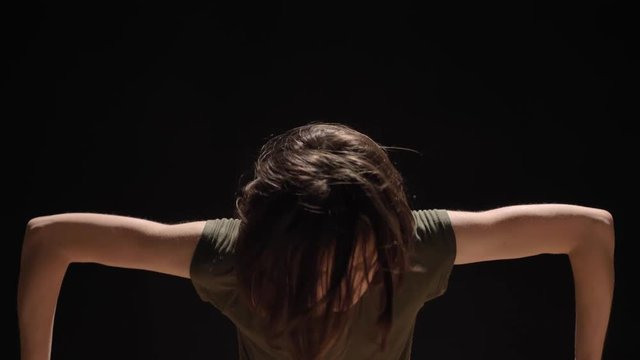 Young charming girl ballerina is dancing with hands, black background, ballet concept, movement concept