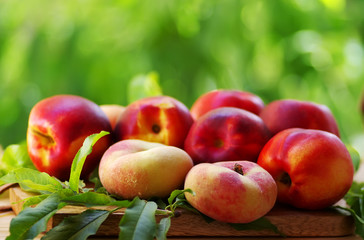 ripe peaches and leaves on table