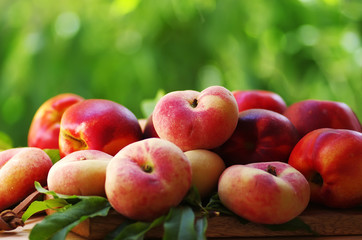 ripe peaches and leaves on table