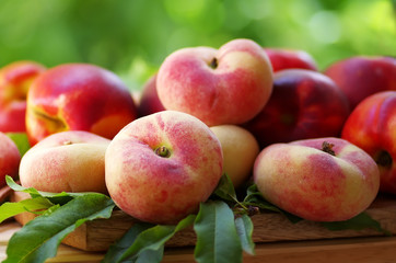 ripe peaches and leaves on table