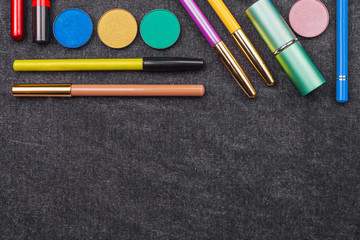 Naklejka premium tools of professional make up artist. lipstick eye pencil mascara and eye shadows. concept of healthy cosmetics. black background and free space for text