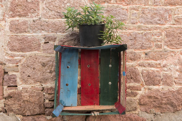 A painted chest and a succulent pot on vinatge wall in Cunda, Ayvalik, Turkey