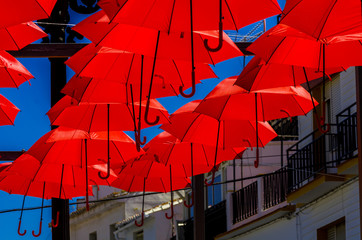 Colourful umbrellas urban street decoration. Hanging colorful umbrellas over blue sky, tourist attraction