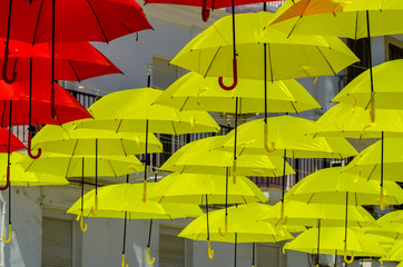 Colourful umbrellas urban street decoration. Hanging colorful umbrellas over blue sky, tourist attraction