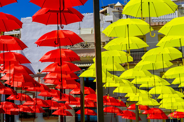 Colourful umbrellas urban street decoration. Hanging colorful umbrellas over blue sky, tourist attraction
