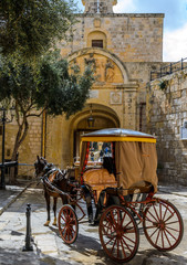 Fototapeta na wymiar Medina, Malta - June 2018: Taking a ride in a chariot in the old city of Medina