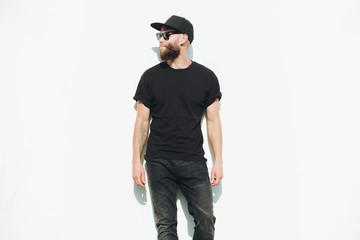 Hipster handsome male model with beard wearing black blank t-shirt with space for your logo or...