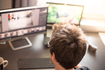 Junger Mann arbeitet an PC, Home-Office, Aufnahme von hinten