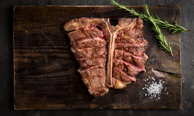 T bone steak grilled sliced on a piece of wood Board