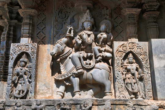 Sculptures on the facade, west side walls. Shiva-Parvati on sitting Nandi. Hoysaleshwara temple, Halebidu, Karnataka
