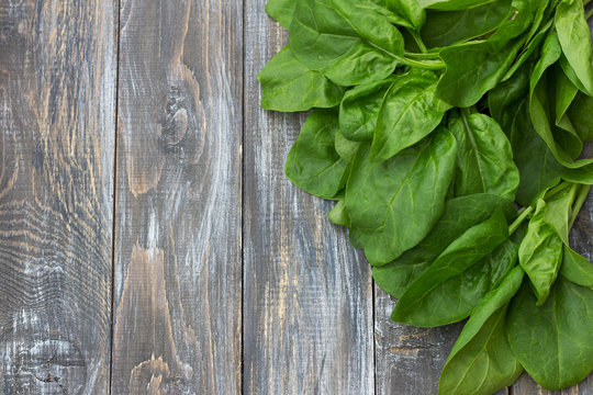 Bunch of fresh spinach with roots on a cutting board with a knife. on a wooden table. rustic style. free space