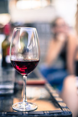 Weinglas mit Rotwein, Gartenparty, Gastgarten in der Abendsonne 