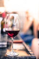 Weinglas mit Rotwein, Gartenparty, Gastgarten in der Abendsonne 