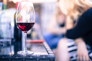 Weinglas mit Rotwein, Gartenparty, Gastgarten in der Abendsonne, Textfreiraum