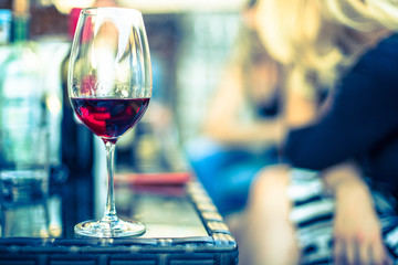 Weinglas mit Rotwein, Gartenparty, Gastgarten in der Abendsonne, Textfreiraum