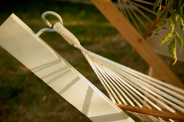 Element, detail, light hammock made of natural materials. Ropes, white cotton and wood. Rest in the garden, in the country