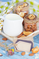 Almonds and jar with milk on the wooden tray