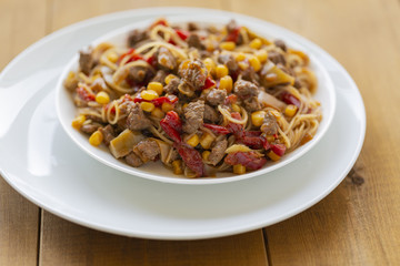 Noodles with meat and vegetables  in sweet and sour sauce.