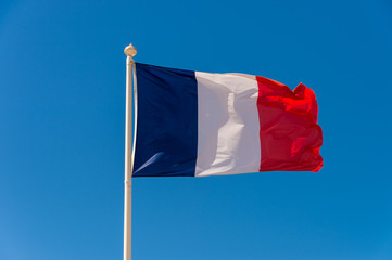 Naklejka na ściany i meble French flag waving against blue sky in Wimereux, France.