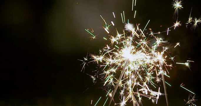 Crisp, slow-motion footage of sparklers burning. This clip is perfect for a background for titles and graphics.