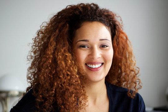 Close up attractive young woman with curly hair smiling